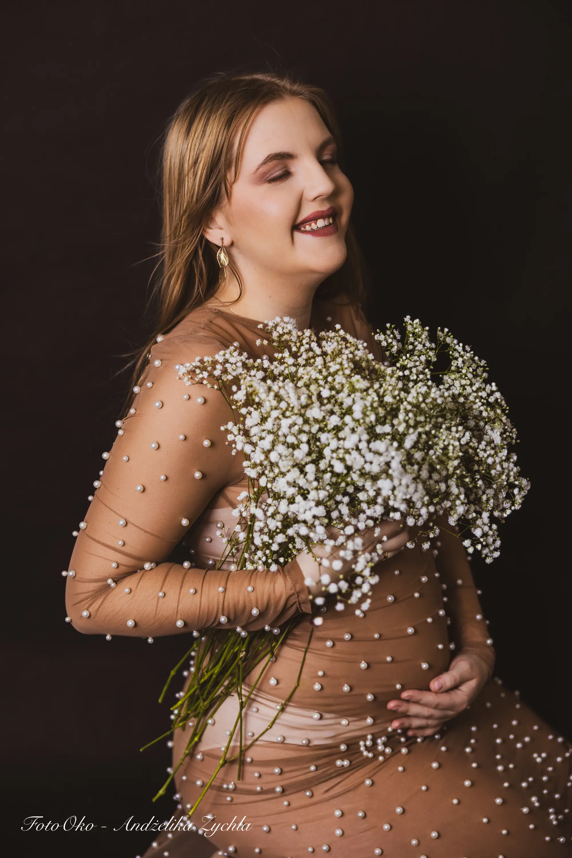 Detale sesji ciążowej, dłonie na brzuszku - profesjonalna sesja brzuszkowa Wieluń